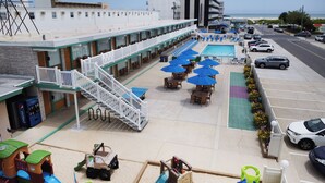 A hotel with outdoor seating, a pool, and a view of the beach. - The VIP Family Motel (Wildwood Crest)