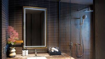 A modern bathroom with a large mirror, a sink, and a shower.