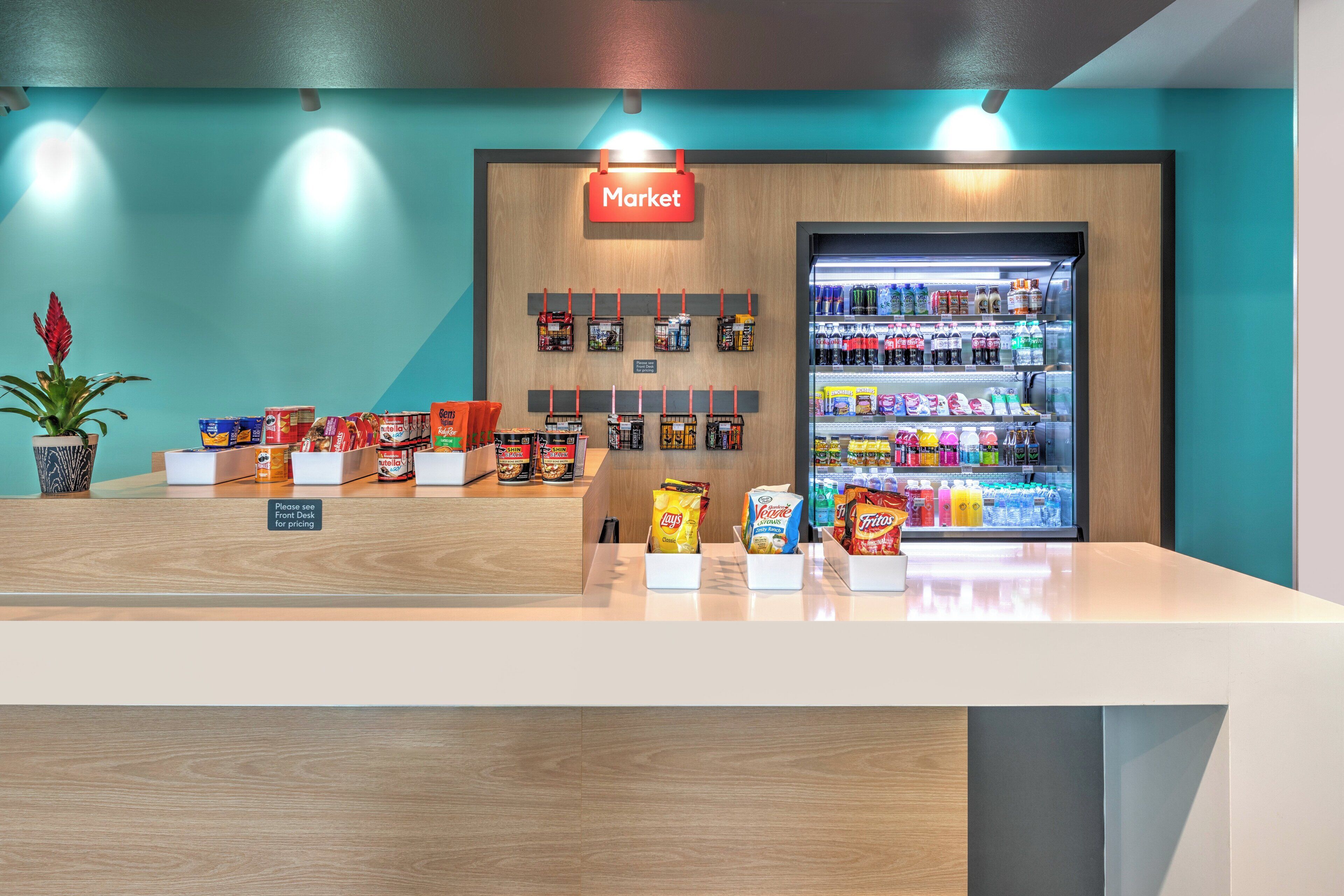 Un espacio comercial limpio y moderno, con una sección refrigerada que exhibe diversas bebidas y aperitivos.