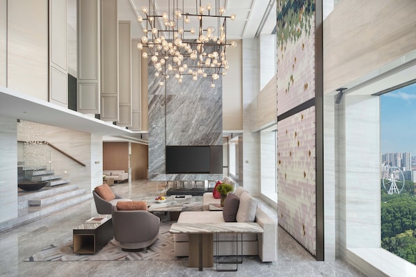 A spacious living area with a modern chandelier, a flat-screen TV, and a city view. - Intercontinental Zhengzhou by IHG (Zhengzhou)