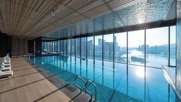 Una piscina interior moderna con vistas claras al horizonte de una ciudad.