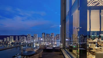 Un immeuble de grande hauteur offrant une vue sur le paysage urbain au crépuscule.