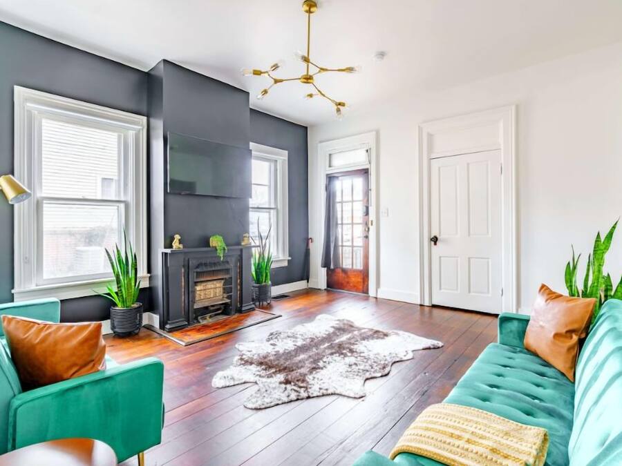 A living room with teal sofas, a fireplace, and a large window.