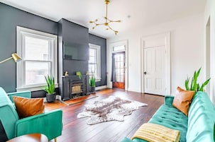 A living room with teal sofas, a fireplace, and a large window.