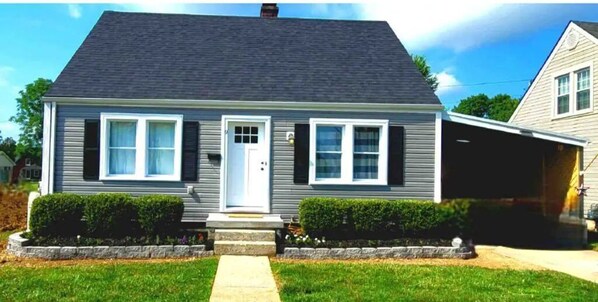 Stylish single-story home with a front entrance, porch, and well-manicured lawn.