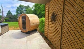 Relax in an outdoor sauna with a door, situated near a unique lattice building.