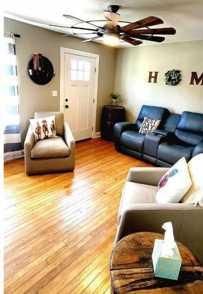 Relax in this inviting living space with a comfortable armchair, sofa, and small table.
