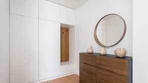 Un interior moderno con un armario de madera, un espejo y jarrones decorativos.