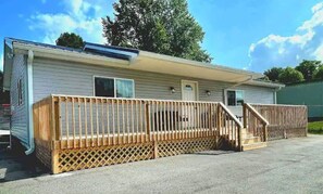 Simple, functional mobile home with a front porch and solar panel.