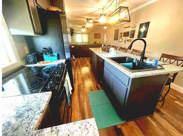 Enjoy cooking in this well-equipped kitchen with a central island, sink, and stove.