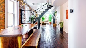 A modern interior with a wooden bench, a staircase, and potted plants. - Jungle House Urban Lofts - Short North & Convention Center (Columbus)