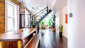 Een modern interieur met een houten bankje, een trap en potplanten.