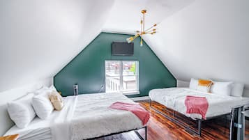 Ein Zimmer mit zwei Betten, einem Fernseher, einer Kristallleuchter und einem Fenster mit Blick.