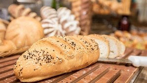 Variedad de panes en una bandeja, incluyendo un pan con semillas de sésamo.