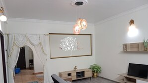 Een woonkamer met een bank, tv-meubel en decoratieve accessoires.