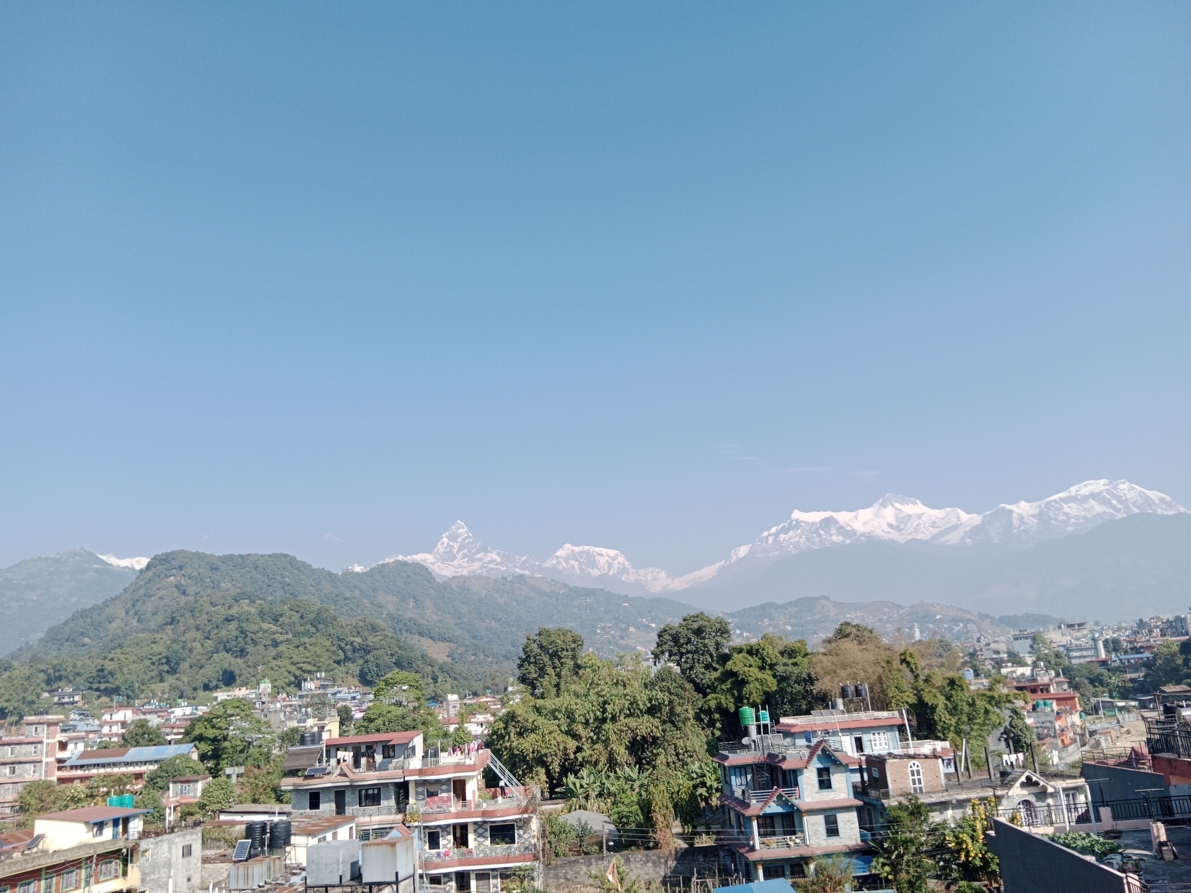 A residential area with houses and a mountainous backdrop.