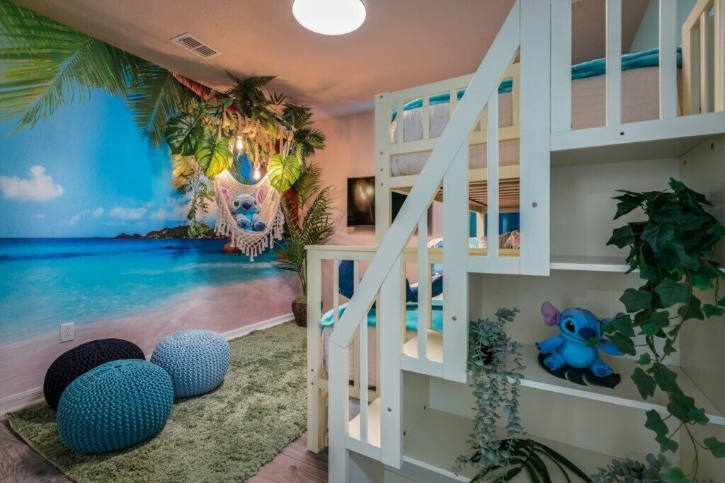 Una habitación con un mural de playa, una hamaca y una cama litera.