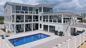 Et toetagers hus med en stor balkon, swimmingpool og grillområde.