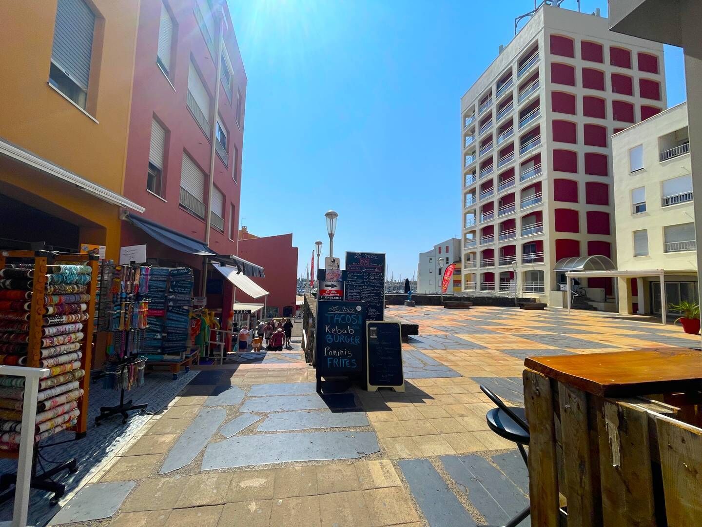 Calle con tiendas y un cartel que anuncia opciones de comida.