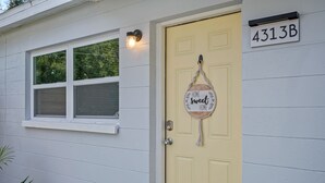 A yellow door with a sign that reads "HOME sweet HOME" and a mailbox with the number "4313B". - Boho Villa B (Tampa)