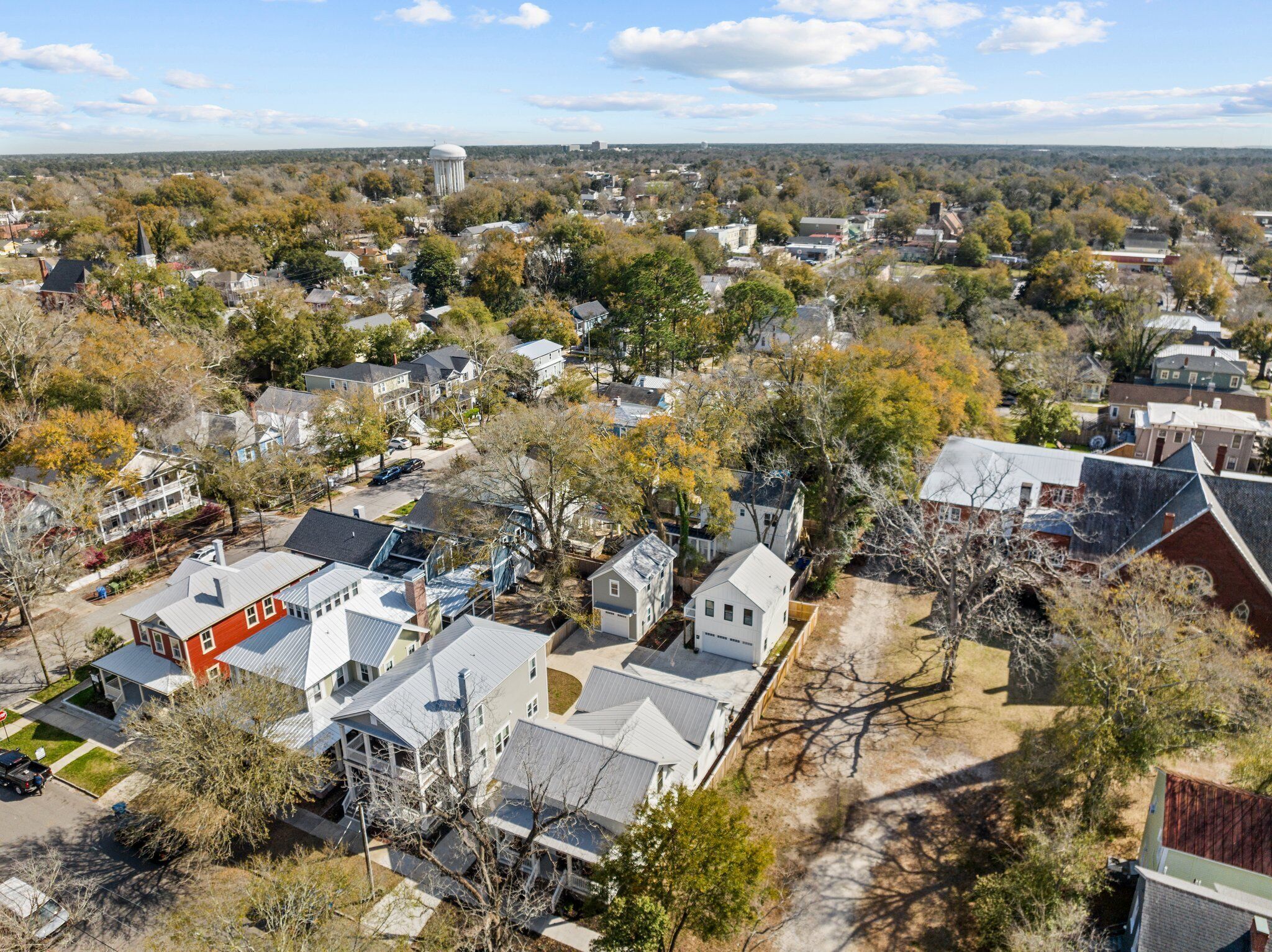 An aerial view of a residential area with houses, trees, and a water tower.