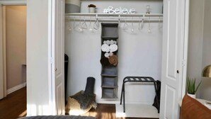 A walk-in closet with a white interior, a #Believe sign, and neatly arranged shelves and hangers. - Bright and Charming Guest House (10 mins from LAX) (Los Angeles)