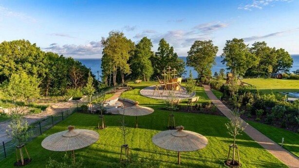 A well-maintained garden with a playground, walking paths, and a view of the sea. - Haffhaus 1 - Haffhaus (Garz)