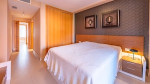 Ein Hotelzimmer mit einem großen Bett, einem Holz-Kopfteil, einem Nachttisch mit Lampe und zwei gerahmten Bildern an der Wand.