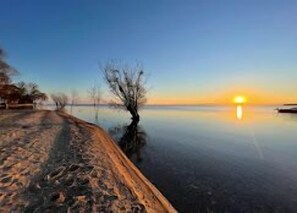 Un lago tranquilo al atardecer con cielo despejado.