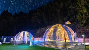 Two dome-shaped structures with transparent walls, illuminated from the inside, set against a backdrop of a starry night sky. - Dream Dome Glamping Studio Ichihara (Ichihara)
