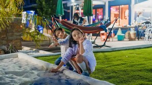 A nighttime outdoor area with a hammock, a pool, and a restaurant in the background. - Dream Dome Glamping Studio Ichihara (Ichihara)