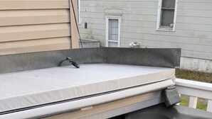 A hot tub with a built-in seat and a water pump.
