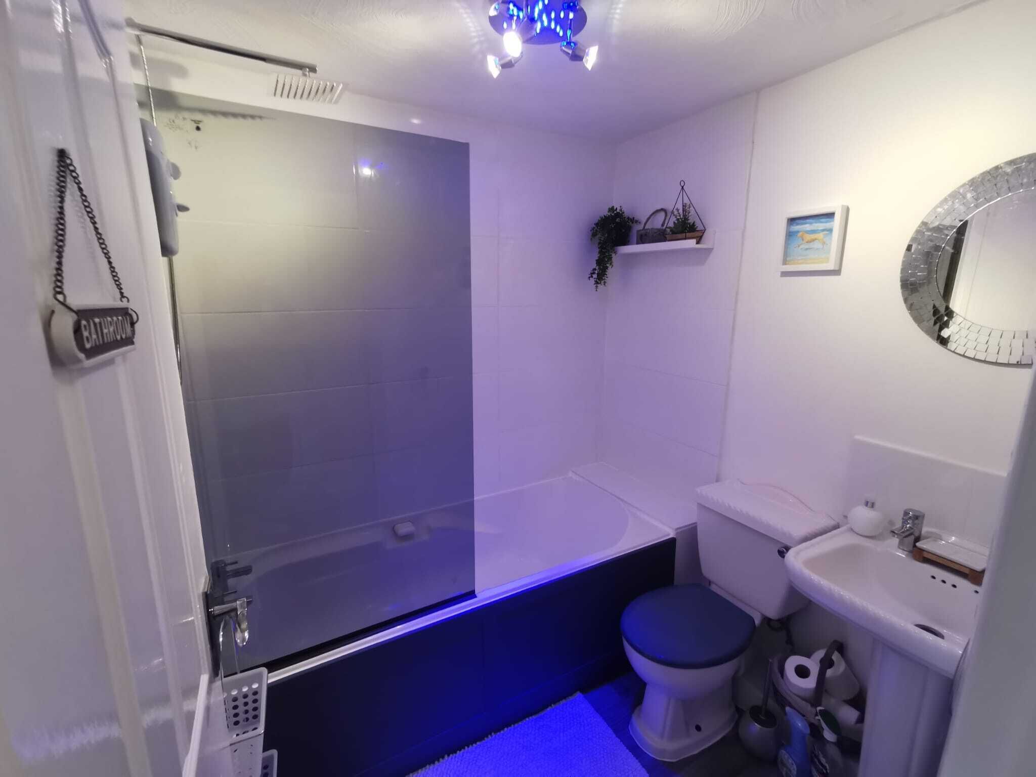 Een badkamer met een douchecabine, een toilet en een wastafel.