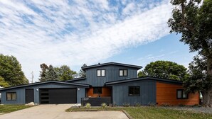 A modern two-story house with a garage, a driveway, and a well-maintained lawn.