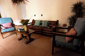 Ein Wohnzimmer mit einem braunen Ledersofa, einem blauen Sessel und einem Holztisch.