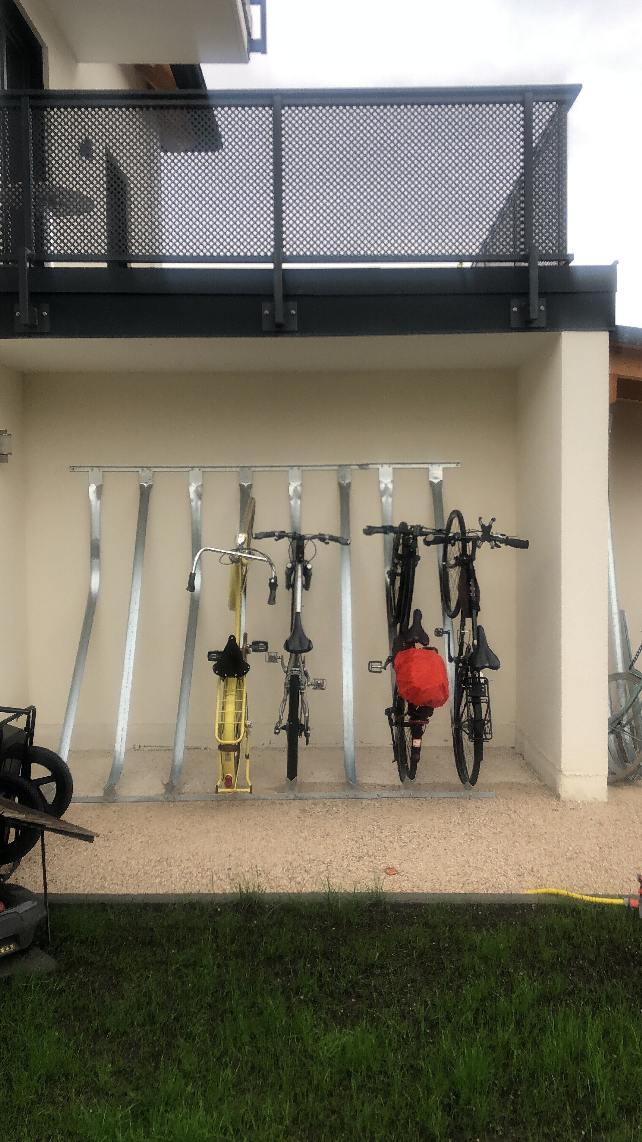 A bike rack with multiple bicycles and a yellow cart.