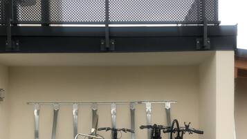 A bike rack with multiple bicycles and a yellow cart.