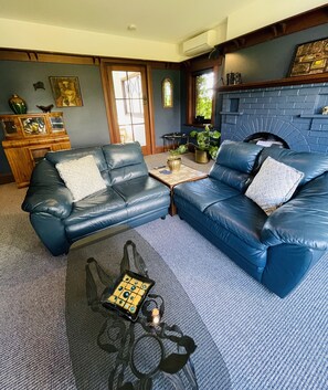 Relax in this stylish living room with a cozy fireplace, comfortable sofa, and natural views.