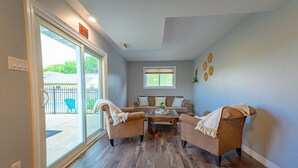 A room with a sliding glass door leading to an outdoor area, a sofa set, and a coffee table. - Entire House with pool in Niagara-on-the-lake close to Niagara Falls (Niagara-on-the-Lake)