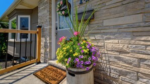 A stone house with the number 146, a welcome mat, and a potted plant with flowers. - Entire House with pool in Niagara-on-the-lake close to Niagara Falls (Niagara-on-the-Lake)
