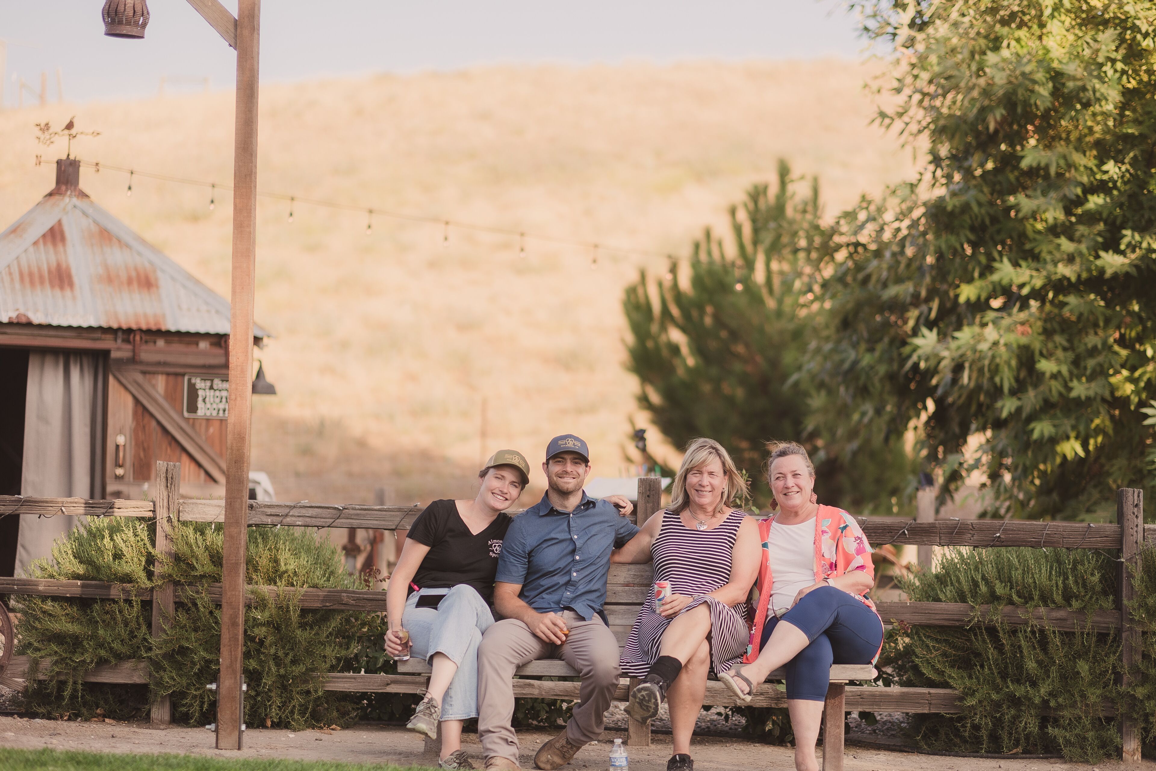 A wooden bench with four people sitting.