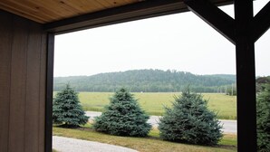 Eine Holzhütte mit Blick auf einen Kiesweg, der zu drei Nadelbäumen führt.