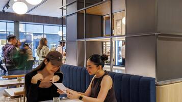 A modern interior with a seating area, tables, and pendant lighting.