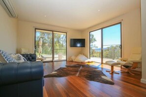 Relax in this stylish living room with a leather sofa, armchair, and flat-screen TV.
