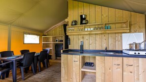 Un intérieur en bois comprenant un coin cuisine, une table à manger, des chaises et une fenêtre.