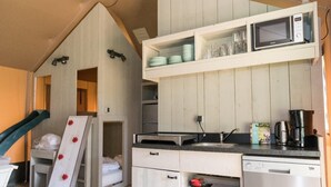 Une cuisine compacte équipée d’un four à micro-ondes, d’un évier et d’une machine à café.