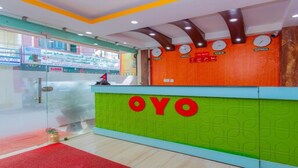 Una recepción con el nombre "OYO" bien visible, un reloj encima y un letrero de 'cerrado por hoy' a la izquierda.