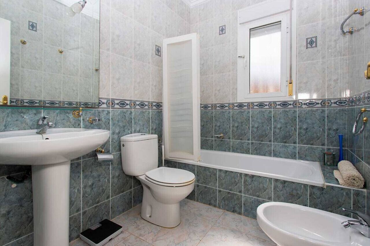 A bathroom with a sink, toilet, bathtub, and bidet.