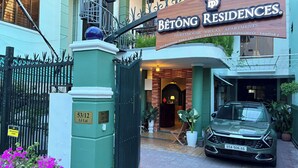 A gated entrance to a building with a sign for 'Bétông Residences' indicating guesthouse, villas, and apartments. - Bê Tông Residences Homestay (Can Tho)