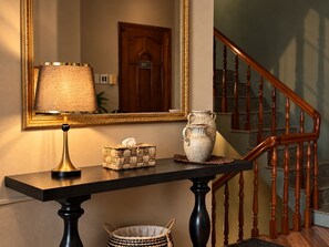A wooden console table with a lamp, a vase, and a basket. - Bê Tông Residences Homestay (Can Tho)